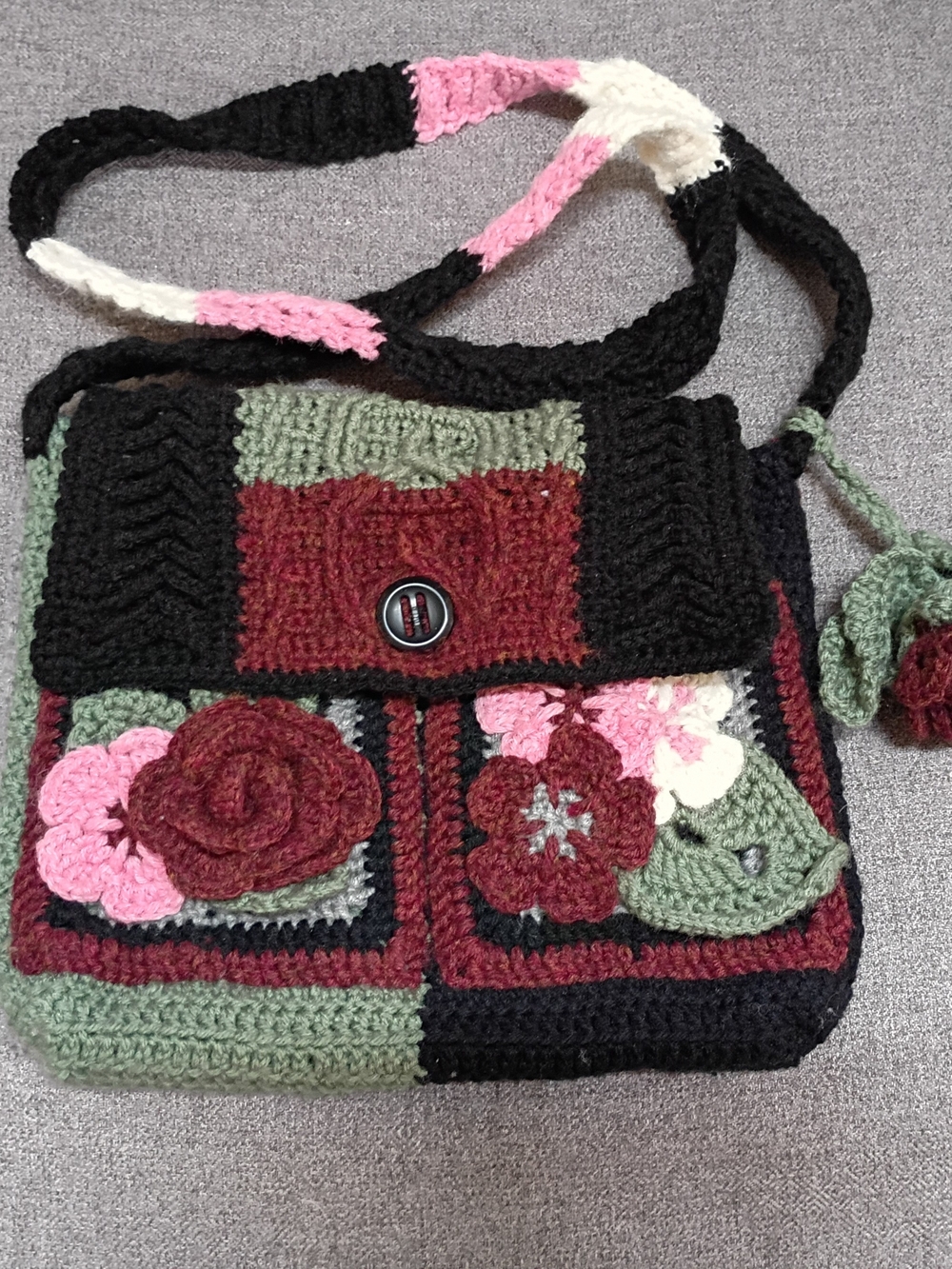 Handmade crochet messenger bag with floral detailing and appliques